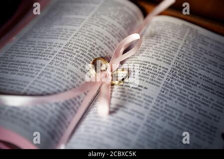 Krawatte mit Eheringen auf der Heiligen bibel in der katholischen Kirche Stockfoto