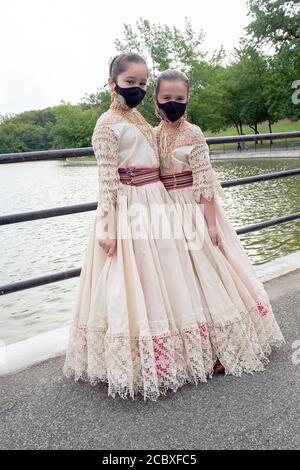 2 junge Mädchen aus einer Gruppe paraguayischer amerikanischer Volkstänzer posieren für ein Foto, während sie ihre OP-Masken tragen. In Flushing, Queens, NY. Stockfoto