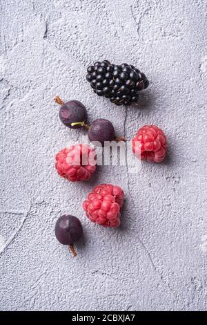 Leckere frische reife Himbeere, Brombeere, Stachelbeere und rote Johannisbeere, gesunde Ernährung Frucht auf steinbetontem Hintergrund, Draufsicht Makro Stockfoto