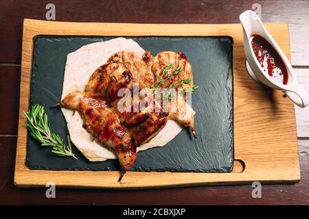 Gegrillte Wachteln im Restaurant auf einem Holzteller Stockfoto