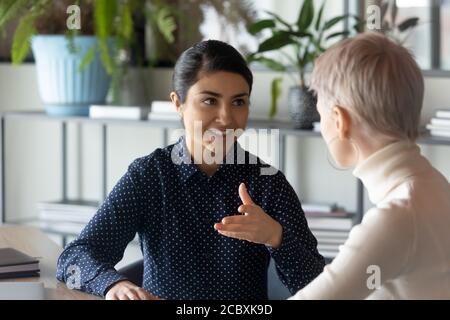 Zwei junge multirassische Angestellte diskutieren Arbeitsfragen. Stockfoto