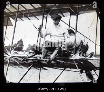 Eine magische Laternenrutsche, die Robert Loraine in seinem Bristol Boxkite Doppeldecker während seines ersten öffentlichen Auftritts als Pilot (unter dem Alias Robert Jones) bei der Bournemouth Aviation Week im Juli 1910 darstellt. Loraine war ein erfolgreicher britischer Bühnenschauspieler, Schauspieler-Manager und Soldat in London und Broadway, der später eine Nebenkarriere als Pionier-Flieger genoss. Im September 1910 machte er den ersten Flug von England nach Irland. Folie herausgegeben von W. Butcher & Sons, London und datiert um 1914. Stockfoto