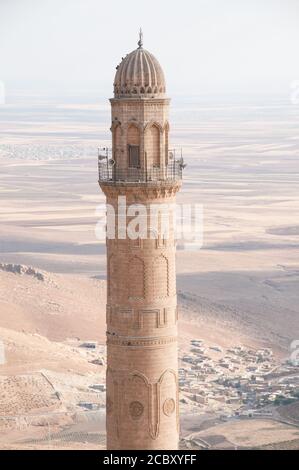 Die Spitze des alten Steinminaretts aus dem 12. Jahrhundert der Großen Moschee (Ulu Cami) in der Stadt Mardin, Region Ostanatolien, Südosten der Türkei. Stockfoto