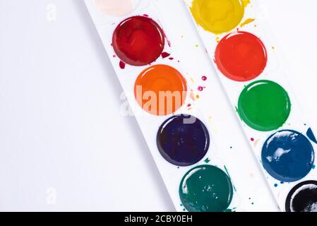 Bunte Aquarell-Pinselstriche, Draufsicht der Pinsel-Palette und Aquarell-Farben mit weißem Papier. Mit Kopierplatz und zum Hinzufügen von Text Stockfoto