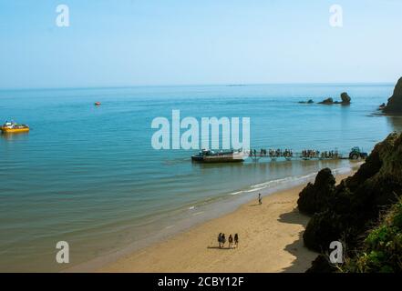 Blick von Tenby Wales UK, Menschen, die Schlange stehen, um auf das Boot zu gelangen Stockfoto