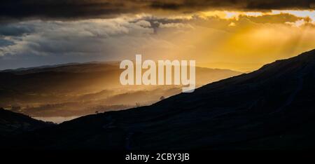 An einem kalten Tag im späten November übergeht die Sonne am späten Nachmittag Ambleside und das nördliche Ende von Windermere. Stockfoto