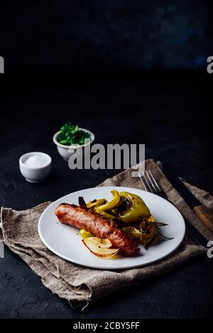 Schweinewurst mit grünen Paprika, Zwiebeln und Kräutern Stockfoto