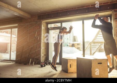 Stattliche aktive kaukasische Paar, als Familie, erfolgreich als Partner, wie Sport Menschen, in crossfit Ausbildung engagiert. Stockfoto