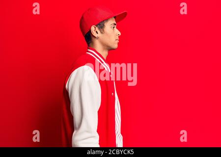 Junger afrikanischer amerikanischer Mann trägt Baseball Uniform suchen zur Seite, entspannen Profil Pose mit natürlichen Gesicht mit selbstbewussten Lächeln. Stockfoto