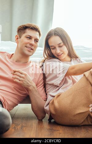 Junge kaukasische Paar genießen Cannabis Marihuana zu Hause zu rauchen, sie entspannen, haben Ruhe zusammen, sitzen auf dem Boden in lässiger Kleidung. Rauchen, Drogen, cann Stockfoto