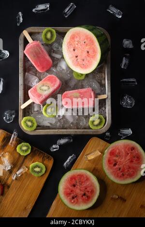 Hausgemachte Wassermelone und Kiwi Eis oder Eis Eis Eis Eis Eis Früchte und Eisstücke auf schwarzem Tisch Stockfoto