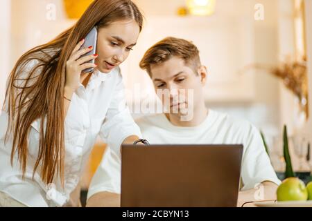 Junge kaukasische Ehepaar auf der Suche nach ihrem ersten Kauf online auf Laptop. Schöne Frau und Mann wollen Hypothek zu bekommen Stockfoto