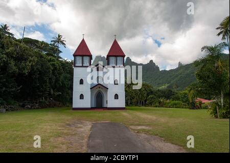 Haapiti Kirche auf der Insel Moorea, Französisch-Polynesien. Sainte Famille Kirche an einem bewölkten Tag mit den schönen Moorea Berge im Hintergrund. Stockfoto