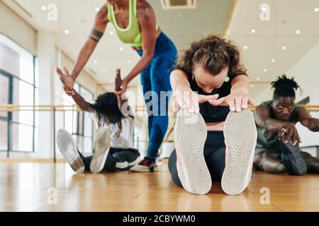 Fit Menschen tun Vorwärtsfaltung Stockfoto