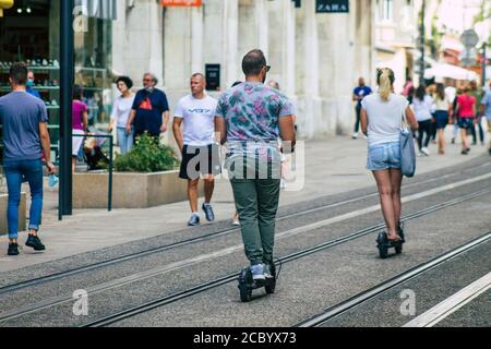 Reims Frankreich August 15, 2020 Blick auf nicht identifizierte Menschen Rollen mit einem Elektroroller in den Straßen von Reims, Betrieb mit einem kleinen Dienstprogramm inte Stockfoto