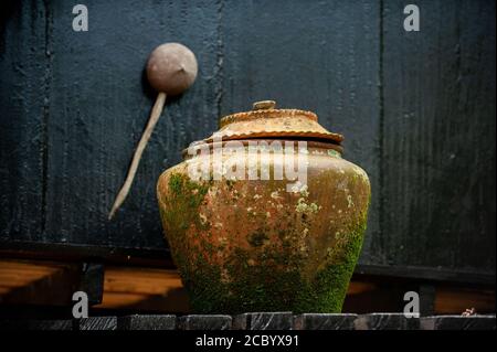 Steingut Schale sieht alt und hat Moos Dunkler Hintergrund Asiaten neigen dazu, Trinkwasser vor dem Haus zu setzen, um eine Spende zu machen. Stockfoto