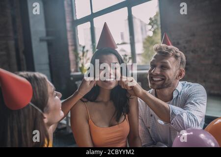 Freunde begrüßen eine Frau während der Geburtstagsfeier Stockfoto