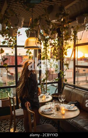Romantisches Abendessen für schöne Frau. Dachterrasse, Gläser für Wein, Kerzen, Marmortisch. Atmosphäre der Liebe. Stockfoto