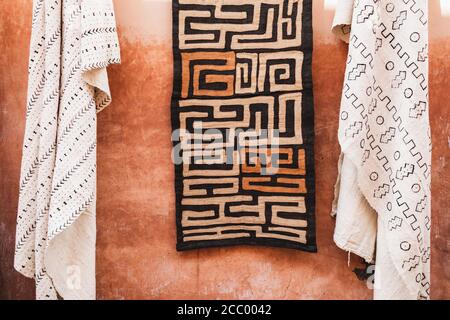 Traditionelle marokkanische Textilien, Teppiche, Teppiche, die an der Hauswand in Terrakotta-Rot hängen. Lokaler Markt in Medina. Herstellung im arabischen Stil. Stockfoto