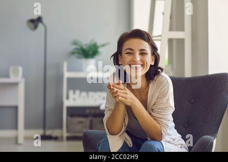 Online-Kommunikation. Fröhliche junge Dame lächelt an der Kamera, während sie mit jemandem im Internet von zu Hause aus spricht Stockfoto
