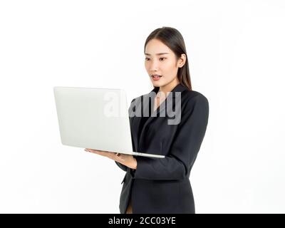 Asiatische Geschäftsfrauen tragen Anzug schockierend, während sie mit Laptop-Computer isoliert auf weißem Hintergrund. Porträt von jungen attraktiven asiatischen Unternehmen e Stockfoto