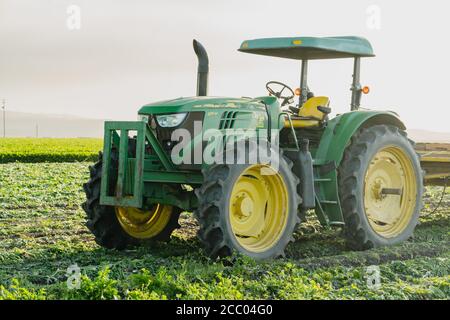 Santa Barbara County, California/USA - 7. Juli 2020 Landwirtschaftliche Feld- und Landmaschinen. Traktor bei Sonnenuntergang auf dem Feld nach der Arbeit stehen Stockfoto