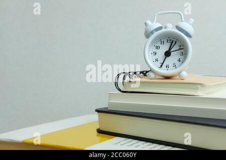 Office Workload Konzept - Stapel von Buch mit Uhr an Die Spitze Stockfoto