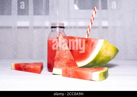 Vitamin Wassermelone Smoothie und Scheiben von frischen roten Wassermelone auf einem weißen Holztisch Hintergrund. Kopieren Raum Stockfoto