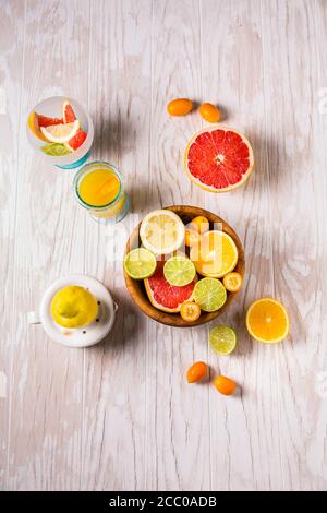 Sortiment von Zitrusfrüchten auf weißem Holzhintergrund. Zubereitung von Limonade, Eistee oder Sommergetränk. Stockfoto