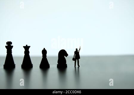 Business-Strategie konzeptionelle Foto - Silhouette von Miniatur-Geschäftsmann zeigt nach oben, stehen vor der Schachspielreihe Stockfoto