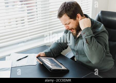 Serious männlichen Unternehmer mit digitalen Tablet und die Arbeit mit Dokumenten. Stockfoto