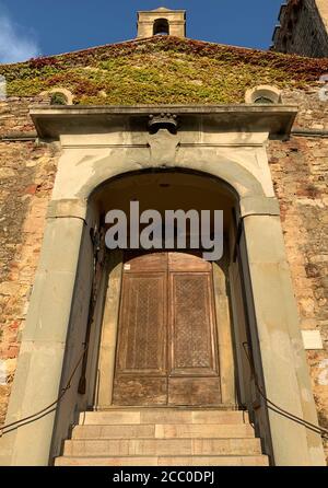 Eintritt in die Kirche San Lorenzo im mittelalterlichen Dorf Castagneto Carducci, Toskana, Italien Stockfoto