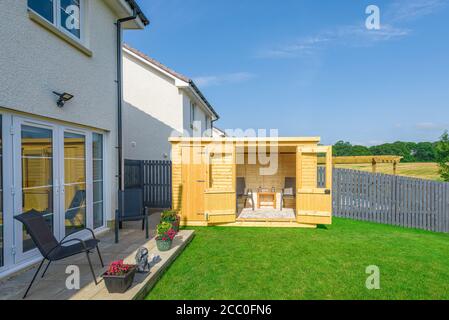 Ein neu fertiggestellten und neu bepflanzten Landschaftsgarten mit Mischer von künstlichen und natürlichen gesät Gras, eine neue Terrasse und Garten Ornamente von neuen umgeben Stockfoto