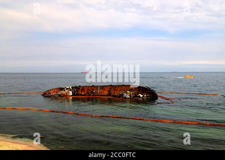 Ein alter rostiger Tanker überflutet und liegt in der Nähe der Küste in Odessa, Ukraine. Öl wird aus dem Schiff verschüttet und verschmutzt das Meerwasser. Umweltverschmutzung Stockfoto