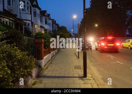 Am frühen Abend, dem 7. August 2020, fahren Autos an Häusern aus der Zeit Edwardians in einer Londoner Wohnstraße in Lambeth, London, England vorbei. Stockfoto