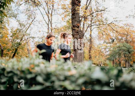 Ein paar Frauen, die draußen durch den Park rannten Stockfoto