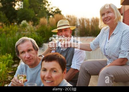 Glückliche Familie, die zum Geburtstag Champagner im Abendgarten trinkt Stockfoto