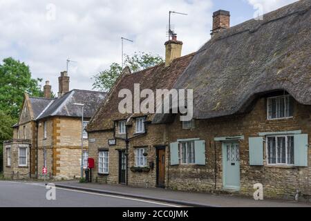 Blick auf die High Street im hübschen Dorf Podington, Bedfordshire, Großbritannien; Reethütte und das alte Postamt Stockfoto