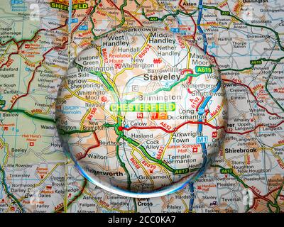 Nahaufnahme einer kuppelförmigen Lupe über einer Seite einer britischen Straßenatlas-Karte, mit der Chesterfield-Gegend von England vergrößert für eine genauere Ansicht. Stockfoto