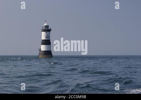 Penmon Point Leuchtturm in der menai Meerenge, Anglesey. Schwarz-weißer Leuchtturm an einem Sommertag Stockfoto