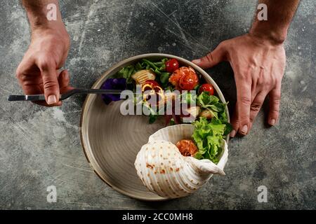 Der Küchenchef bereitet einen Salat mit Meeresfrüchten und Gemüse. Stockfoto