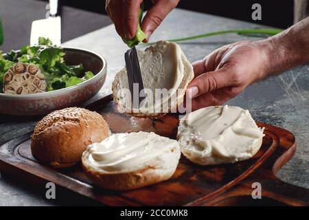 Der Koch kocht Burger im Restaurant. Stockfoto