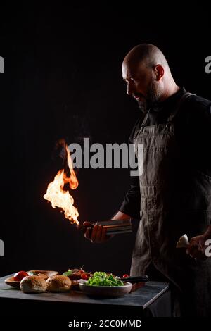 CEF kocht Burger, röstet Fleischbällchen auf offenem Feuer. Stockfoto