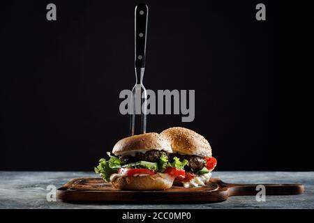 hamburger mit Fleischbällchen auf schwarzem Hintergrund. Stockfoto