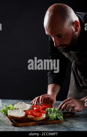 Der Koch kocht Burger im Restaurant. Stockfoto