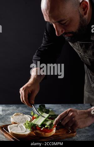 Der Koch kocht Burger im Restaurant. Stockfoto