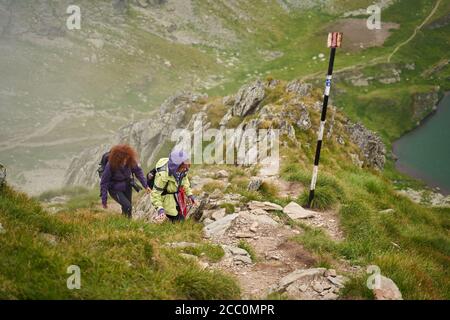 Zwei Freundinnen Touristen mit Rucksäcken zusammen wandern in der Berge Stockfoto