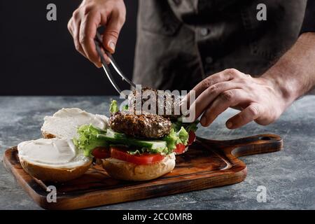 Der Koch kocht Burger im Restaurant. Stockfoto