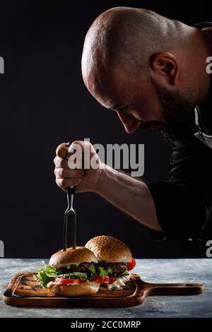 Der Koch kocht Burger im Restaurant. Stockfoto