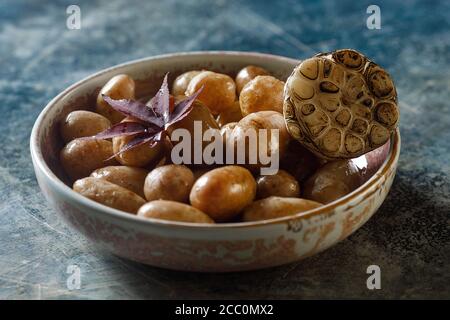 Gekochte junge Kartoffeln mit Öl und gerösteten Knoblauch, in einer Holzschale. Stockfoto